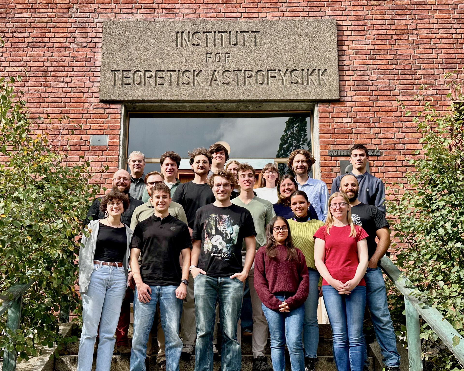 Group photo of students of the course standing in front of a building with red bricks.